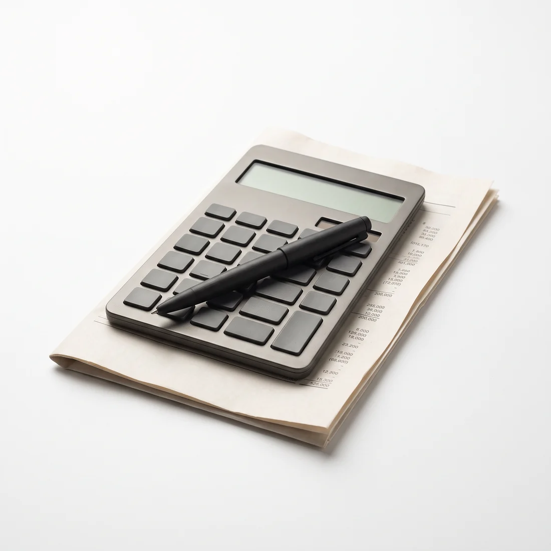 A calculator, fountain pen and printed statement arranged on a desk